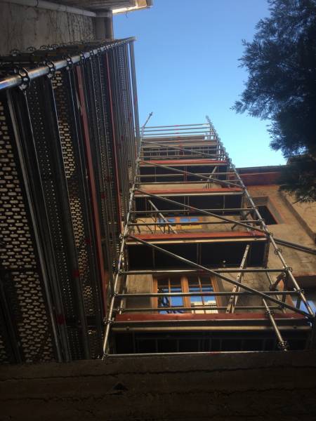 Montage d'échafaudage pour rénovation de façade dans une cour d'Aix en Provence